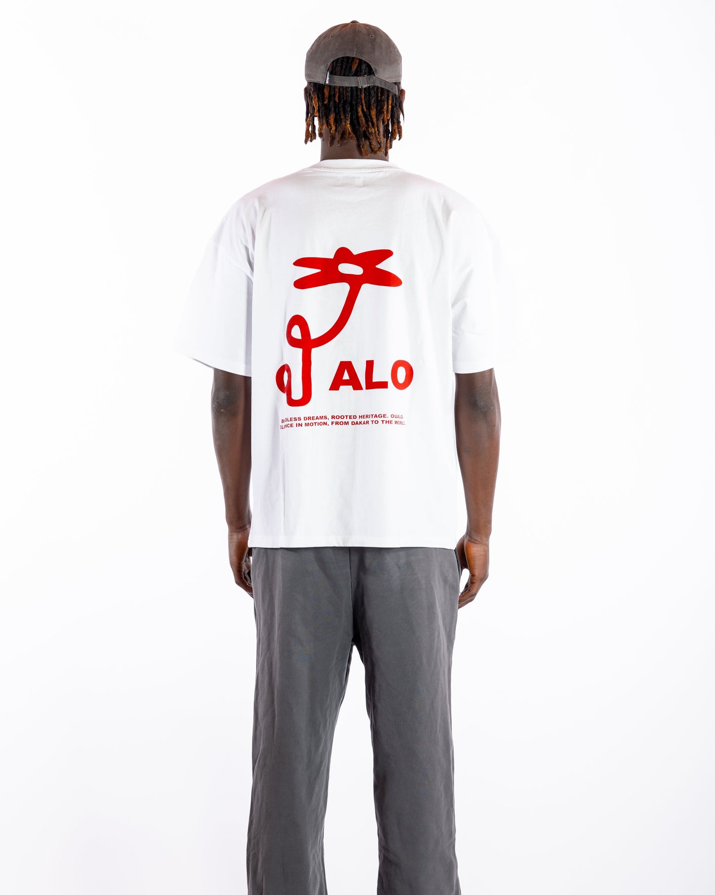 Person wearing a white t-shirt with red graphics and text, standing against a white background