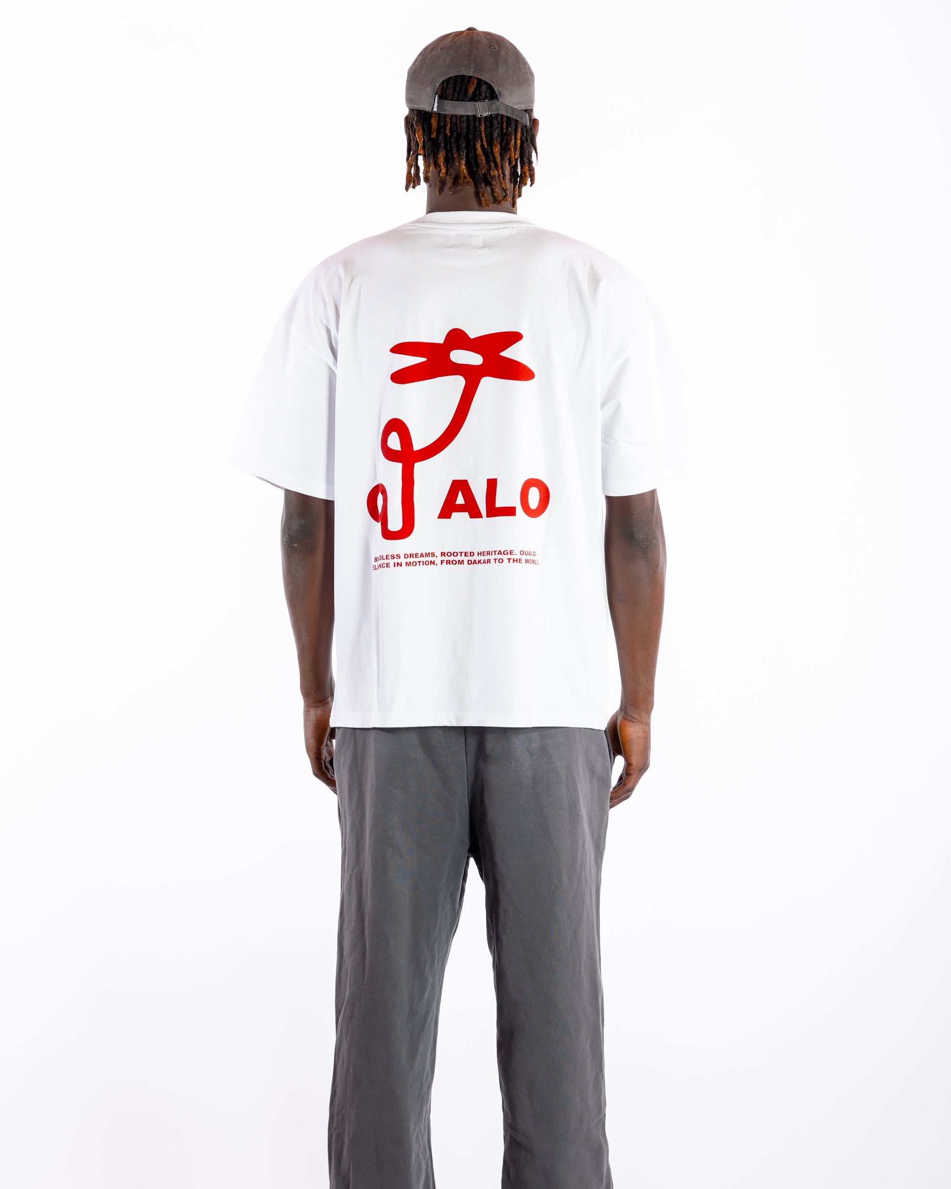 Person wearing a white t-shirt with red graphics and text, standing against a white background