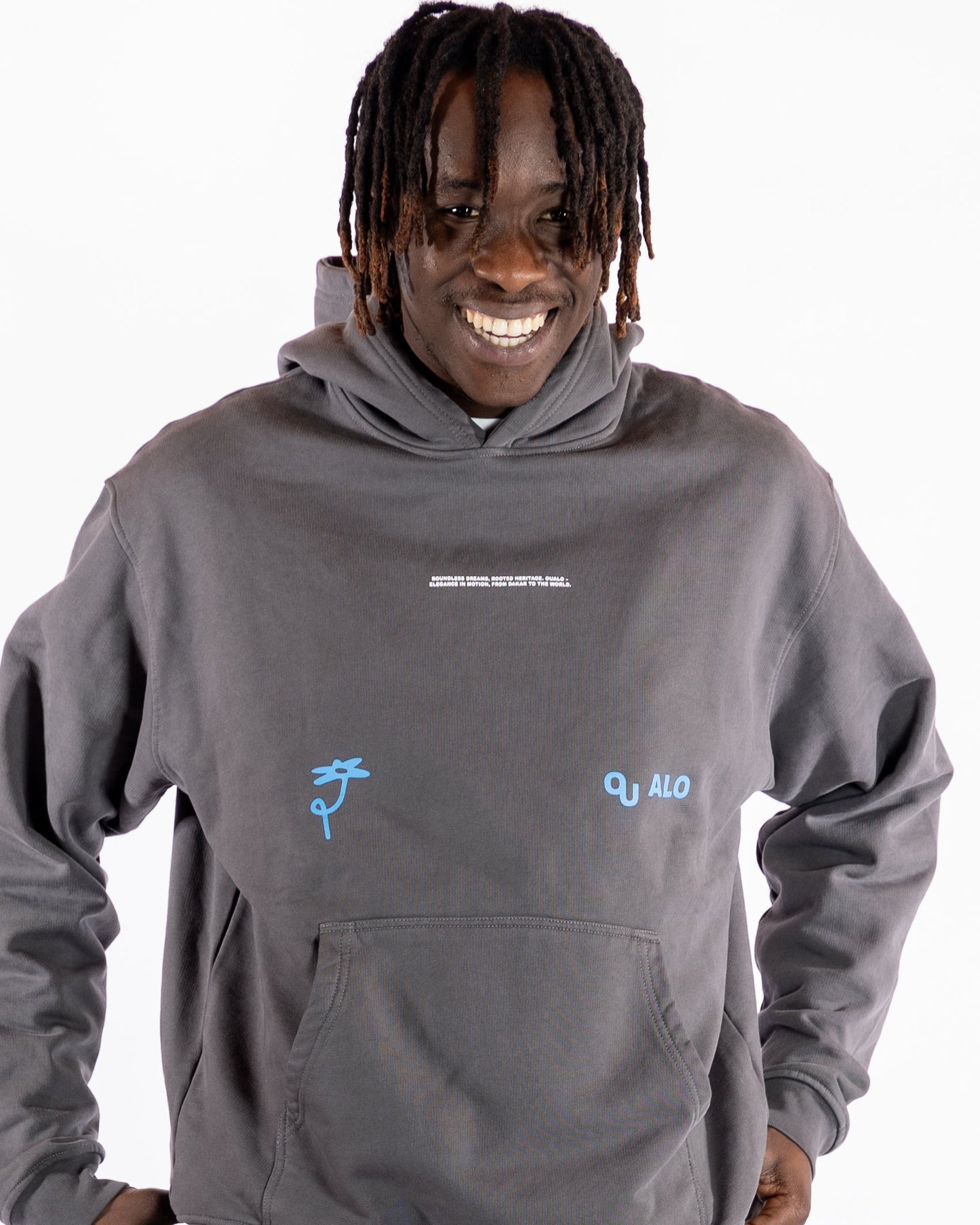 Person wearing a grey hoodie with logos on a white background